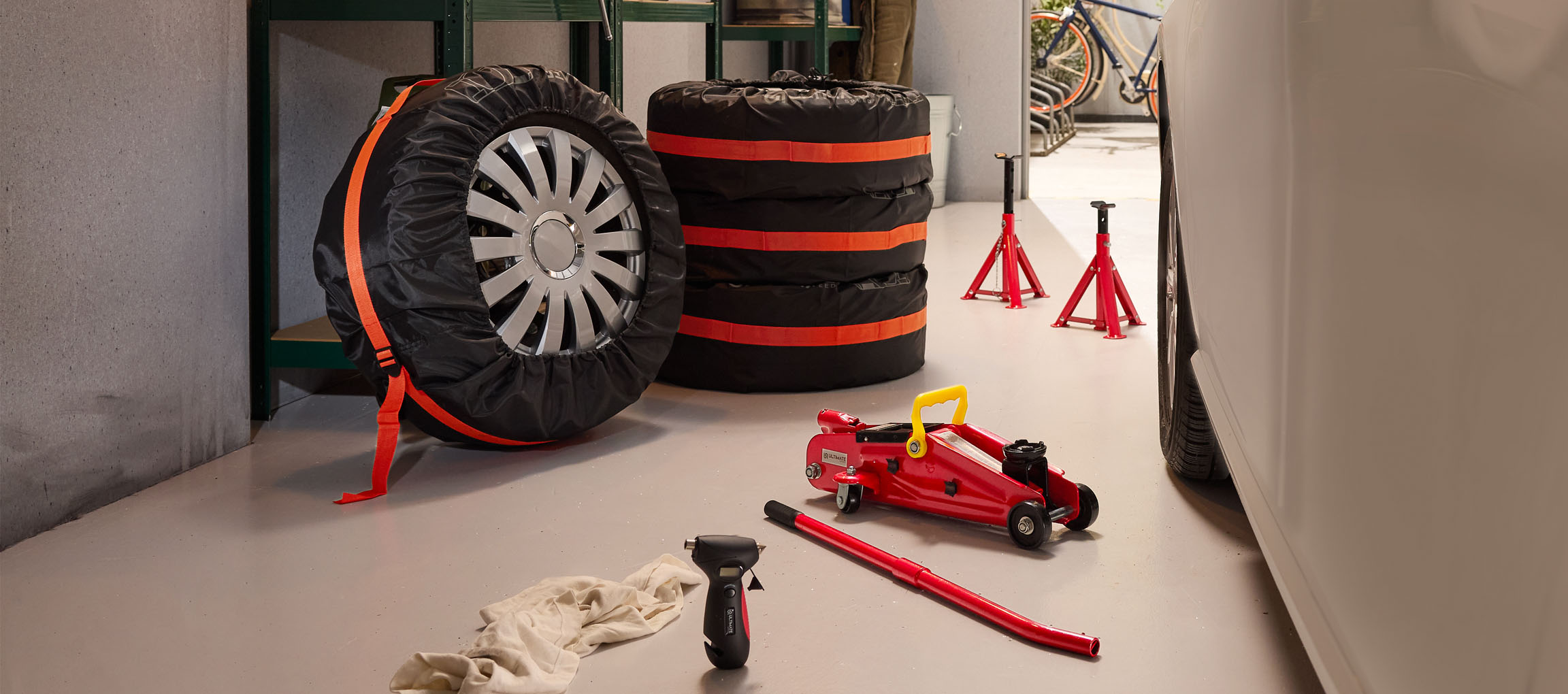 Autógumik huzattal, emelő és bakok egy garázsban.