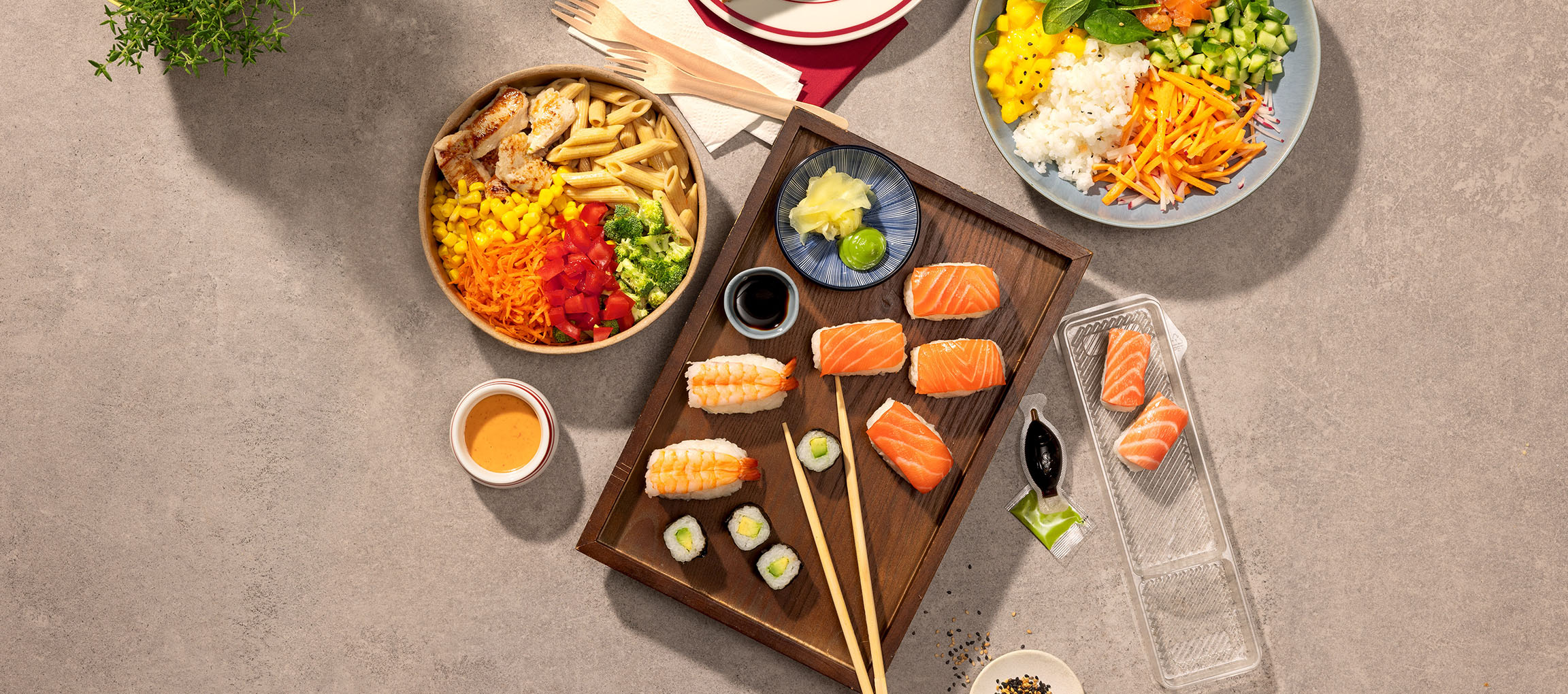 Válogatott ételek: tészta- és csirketál, sushi és poke tál az asztalon.