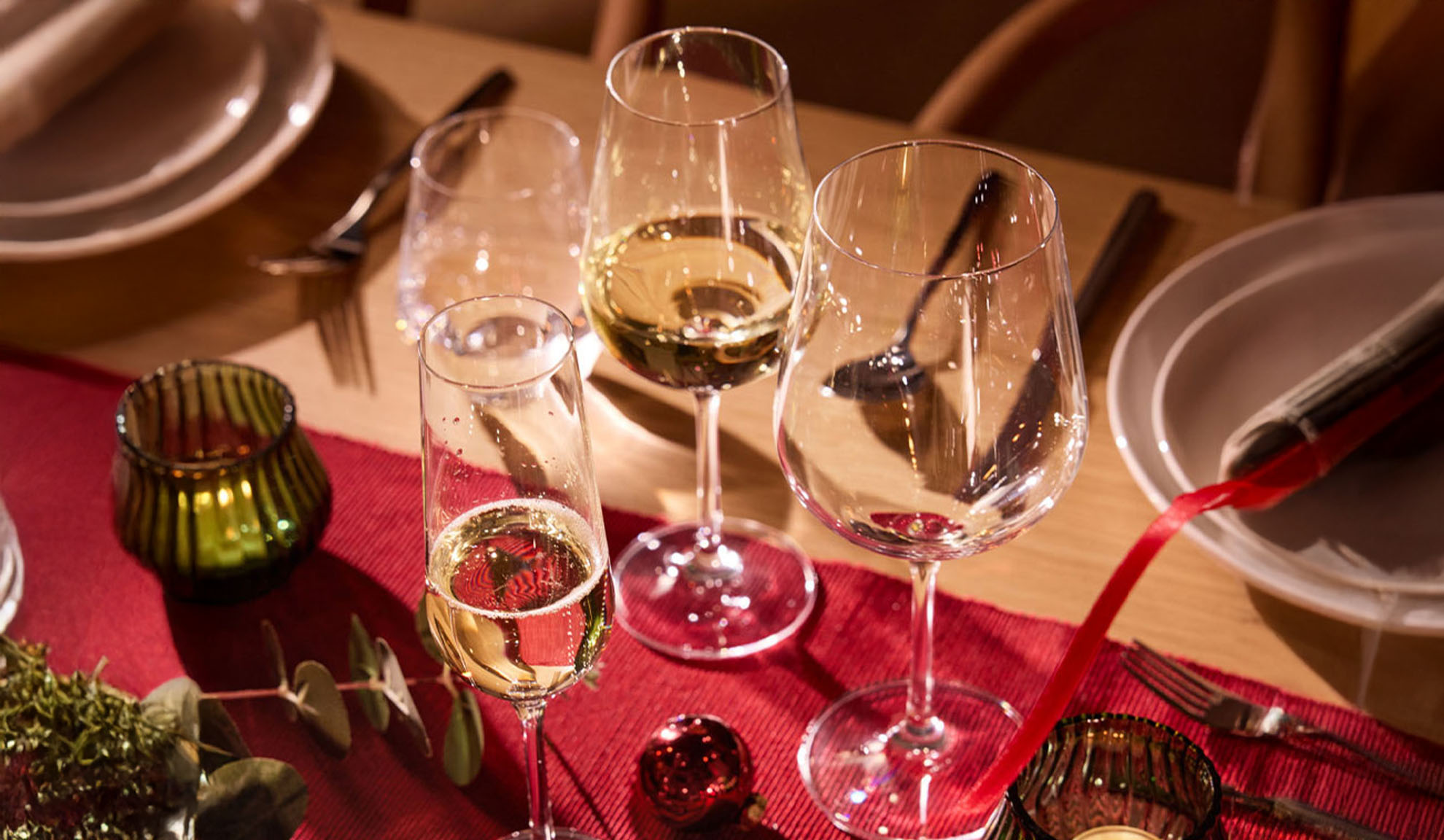 Ünnepi asztal borospoharakkal, pezsgőspohárral és karácsonyi dekorációval.