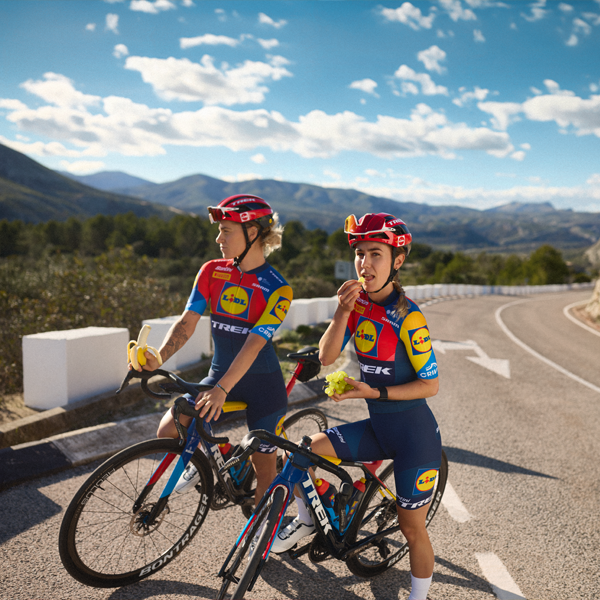Két Trek-Segafredo Lidl csapat kerékpárosa gyümölcsöt eszik egy szünetben.