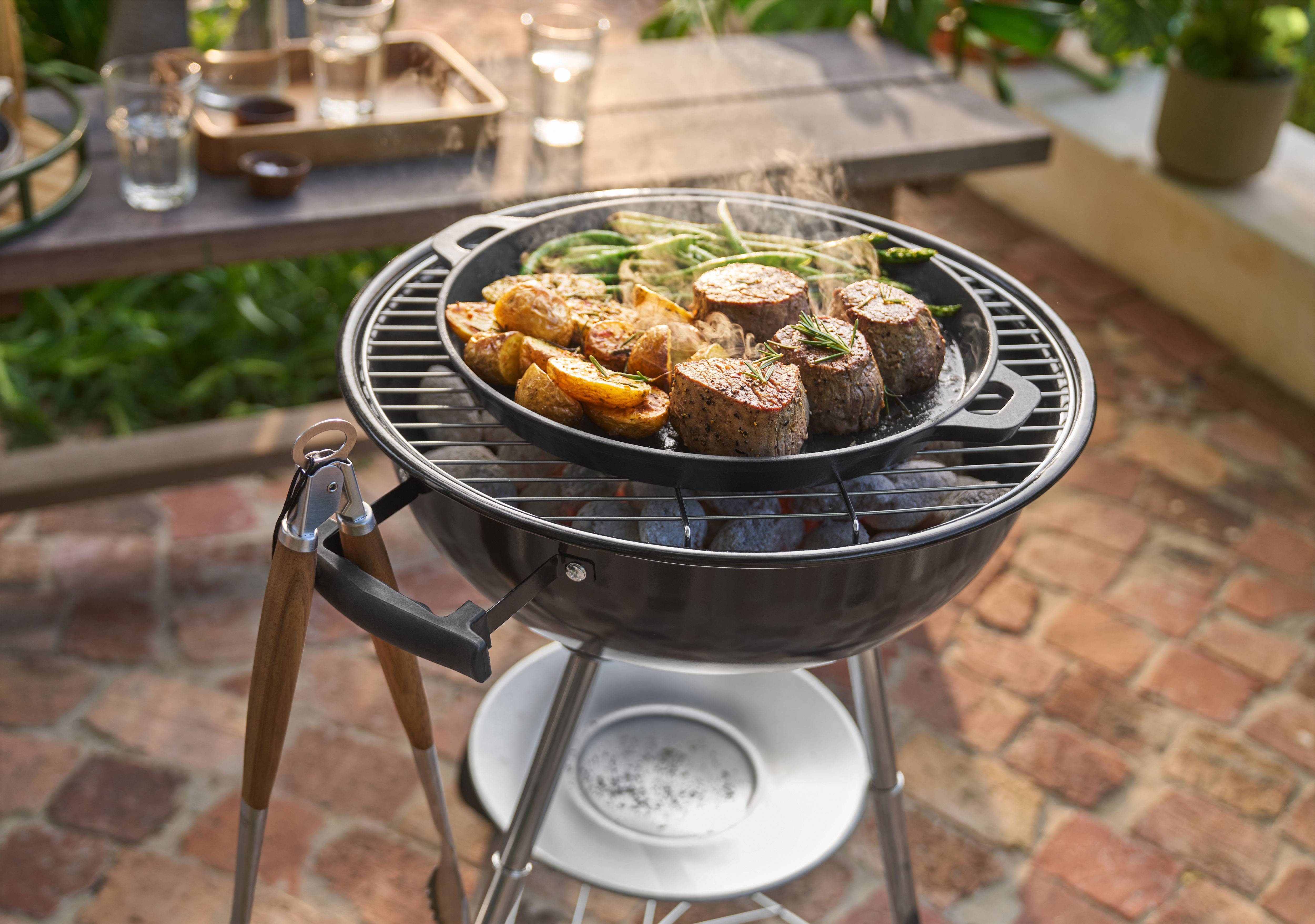 Grill húsokkal, burgonyával és zöldbabbal serpenyőben, a szabadban sütve.