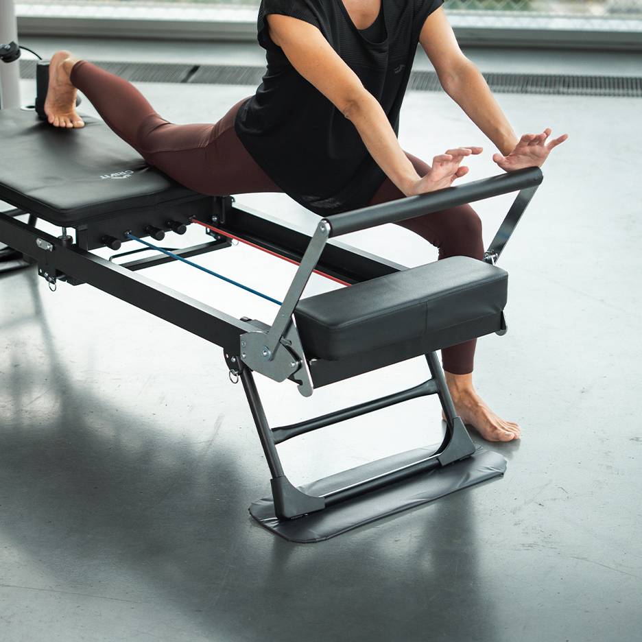 Nő edz egy Pilates gépen sportruházatban