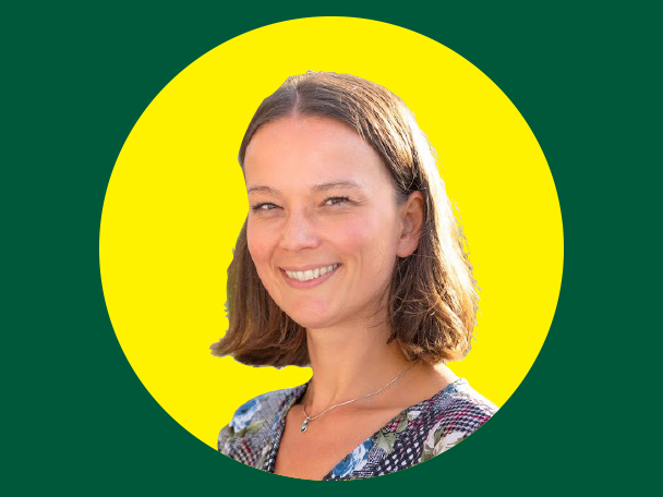 Mosolygó nő portréja sárga körben, zöld háttérrel.