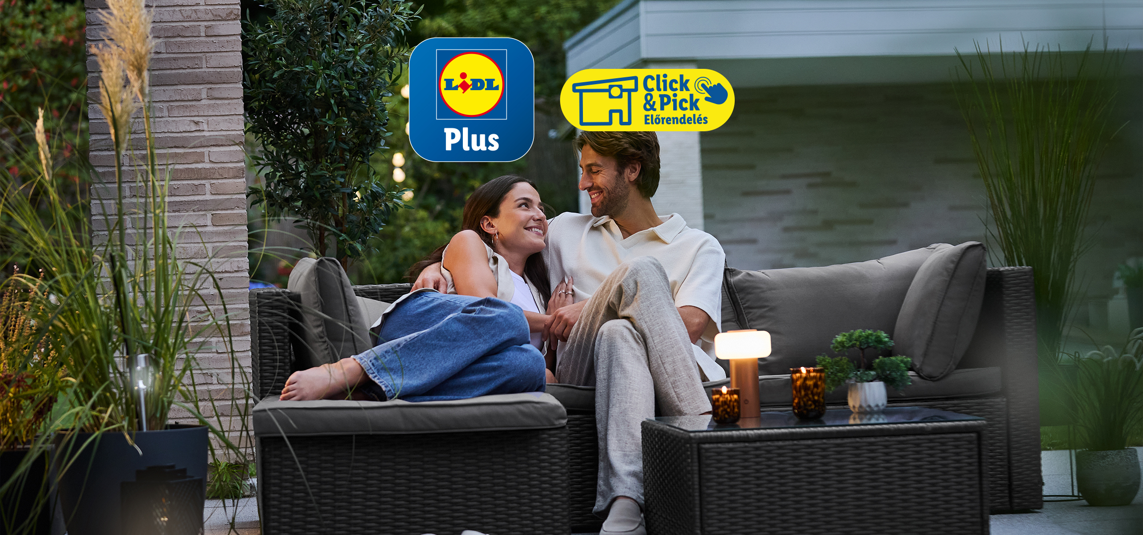 Pár ül a kerti bútoron, háttérben kőfal és növények, a képen a Lidl Plus és Click & Pick logók láthatók.