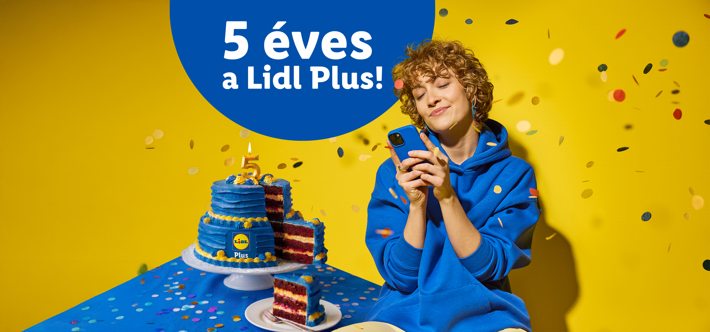 5 éves a Plus! felirat, torta és egy nő telefonnal, konfettivel.