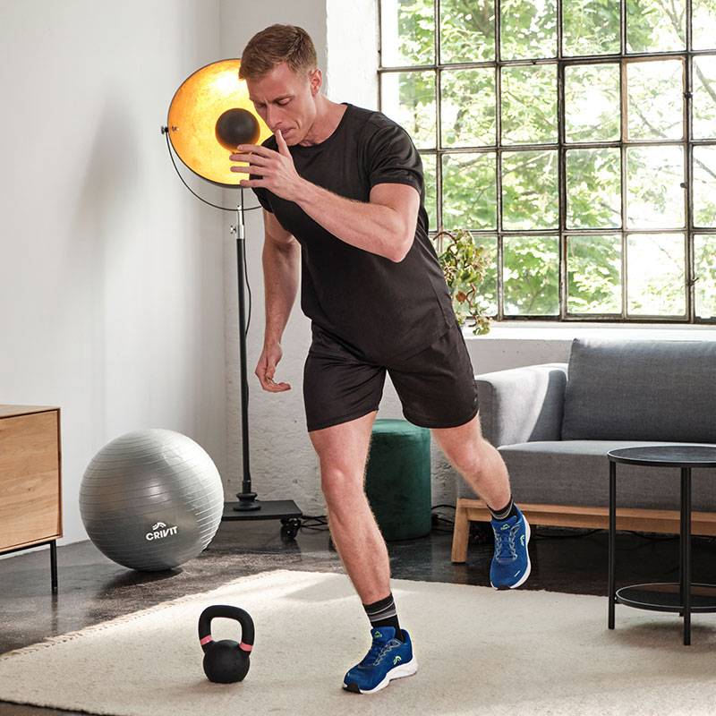 A férfi Crivit medicinlabdával, kettlebell-lel és tornabállal edz