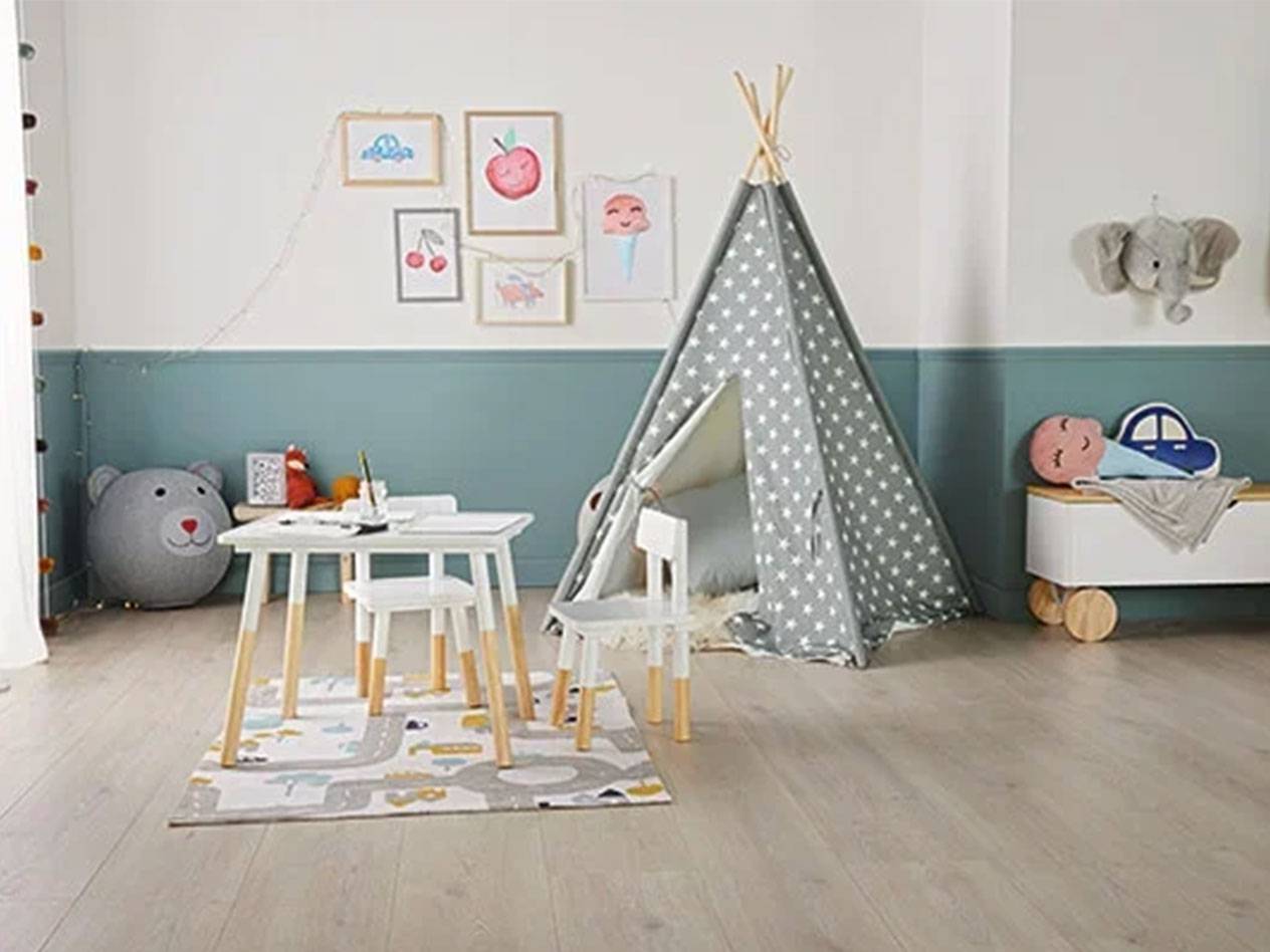 Gyerekszoba tipi sátorral, asztallal és székekkel, játéktároló ládával és képekkel a falon.