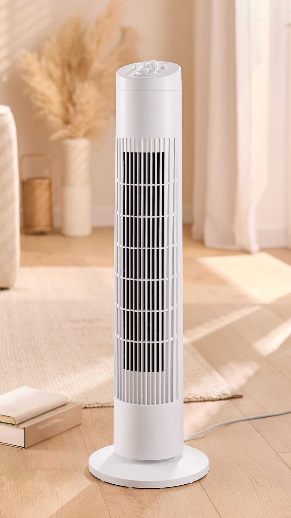 Fehér toronyventilátor világos, modern nappaliban, bézs szőnyegen és fapadlón.