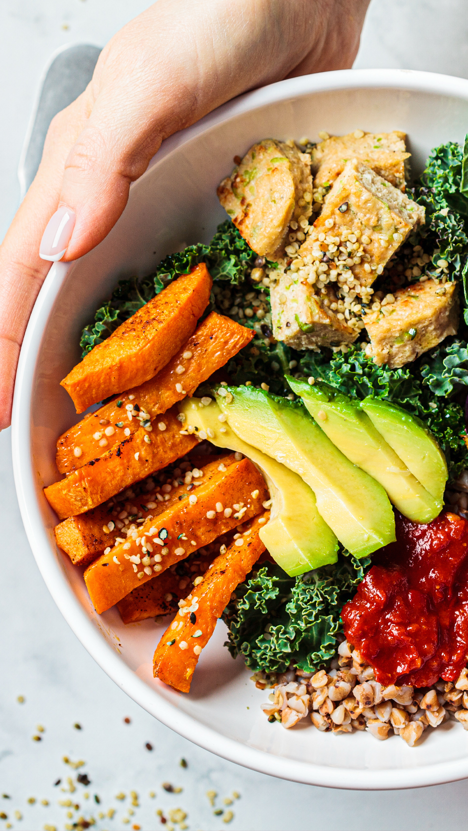 Egy tál sült édesburgonya, avokádó, kelkáposzta, tofu és hajdina.