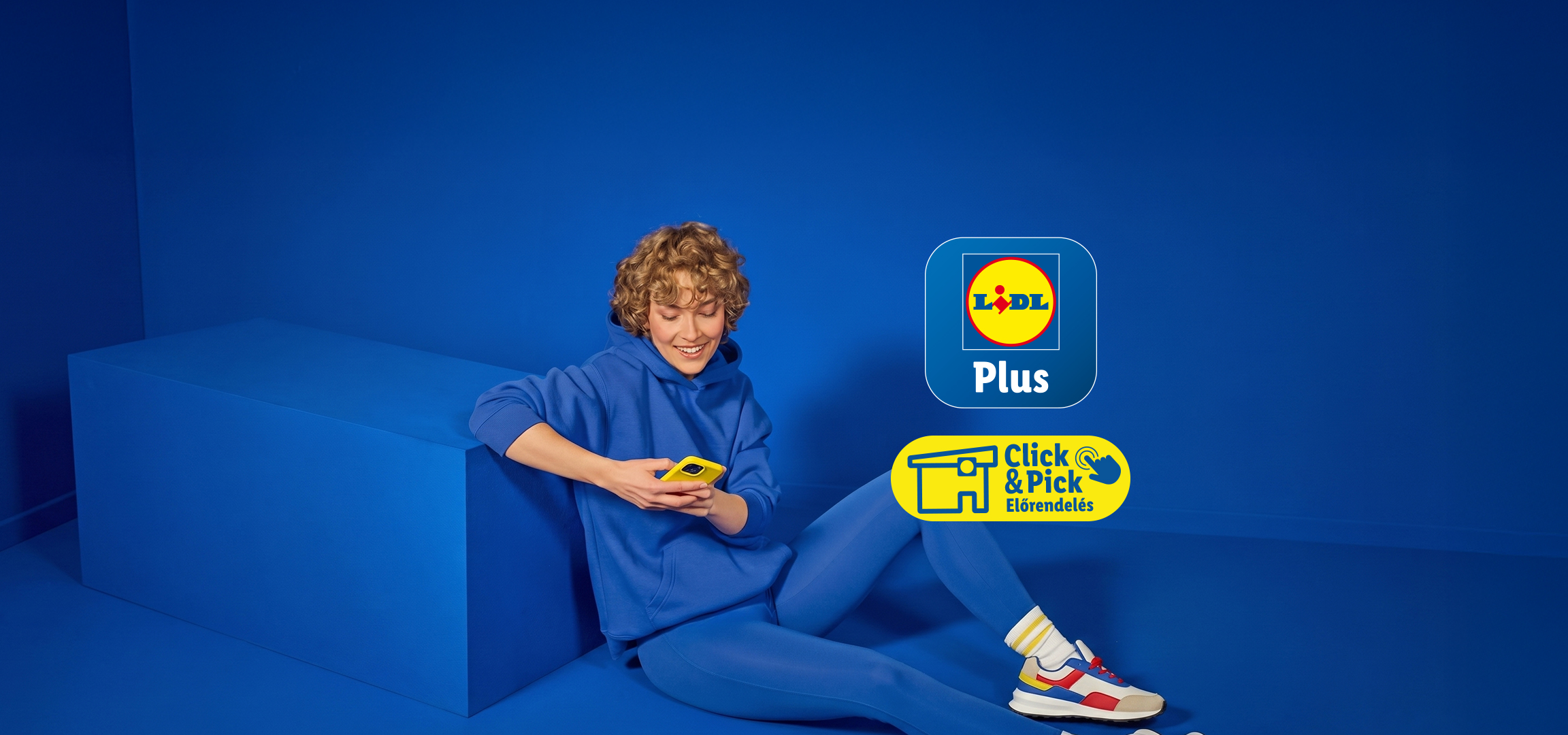 Fiatal nő kék ruhában, telefonnal a kezében, a Lidl Plus és Click & Pick logókkal.