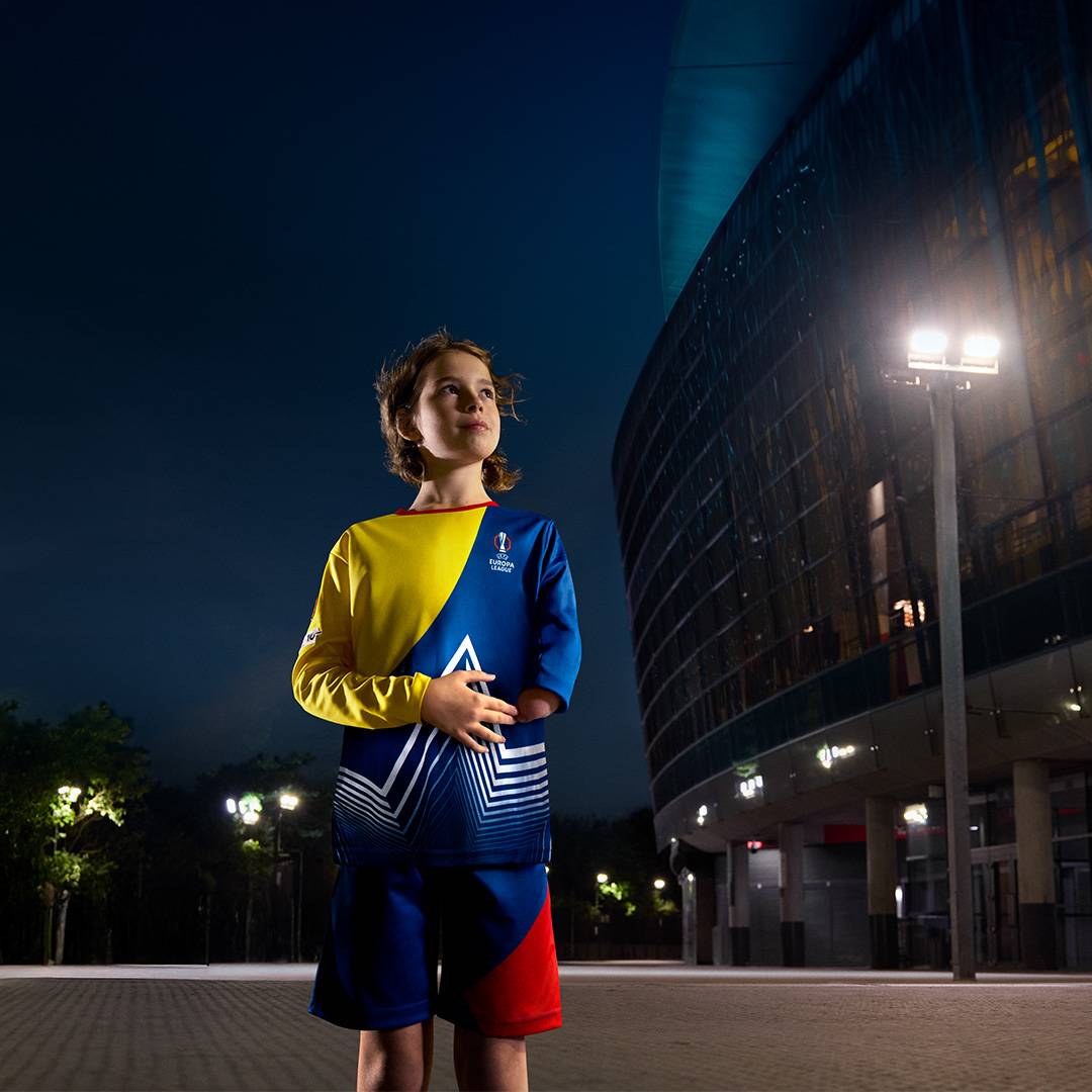 Gyermek focimez és rövidnadrág a Europa League logóval, stadion előtt.