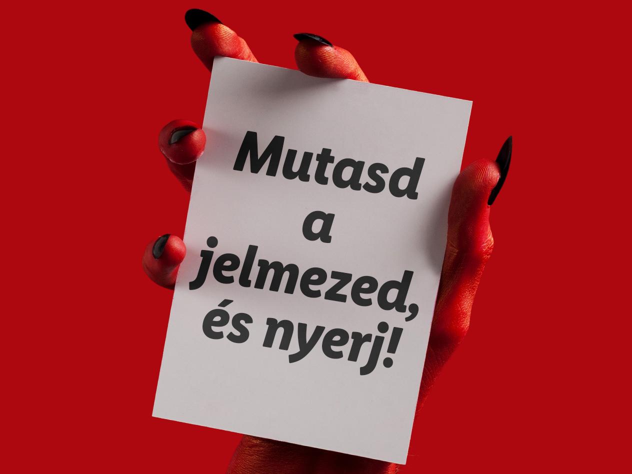 Piros kéz fehér kártyát tart, rajta 'Mutasd a jelmezed, és nyerj!' felirattal.