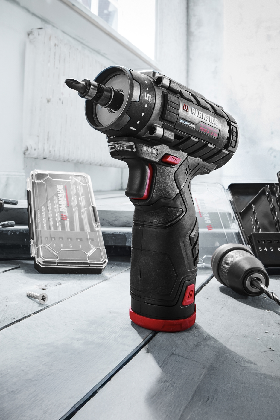 PARKSIDE akkus fúró-csavarozó, fúrófejekkel és csavarokkal egy asztalon.