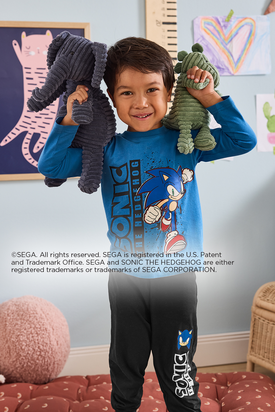 Fiú Sonic the Hedgehog pólóban és nadrágban, plüssállatokkal.