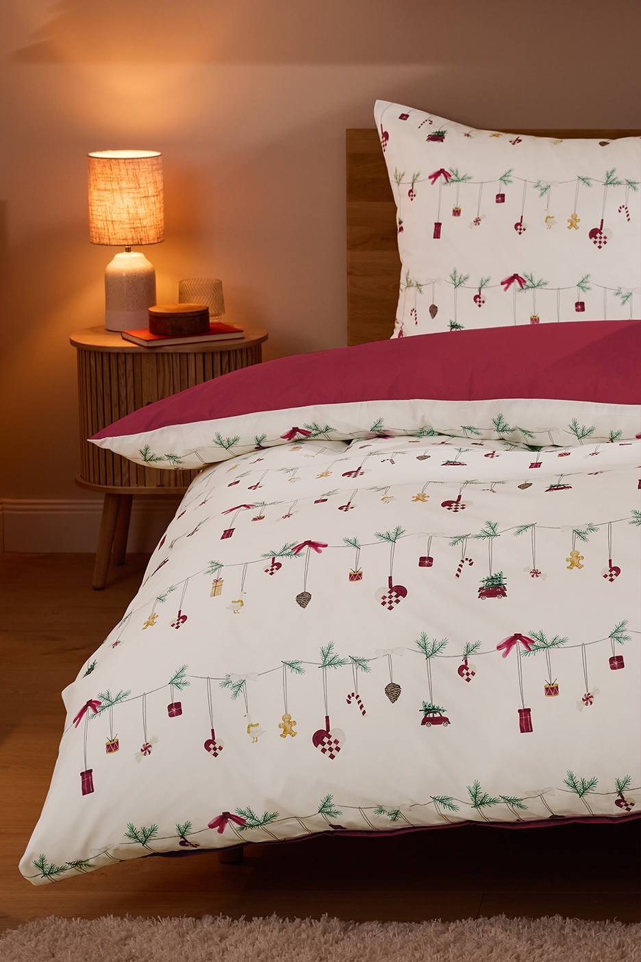 Karácsonyi ágynemű szett házikó és fenyőfa mintával, gyertyákkal és ünnepi dekorációval.