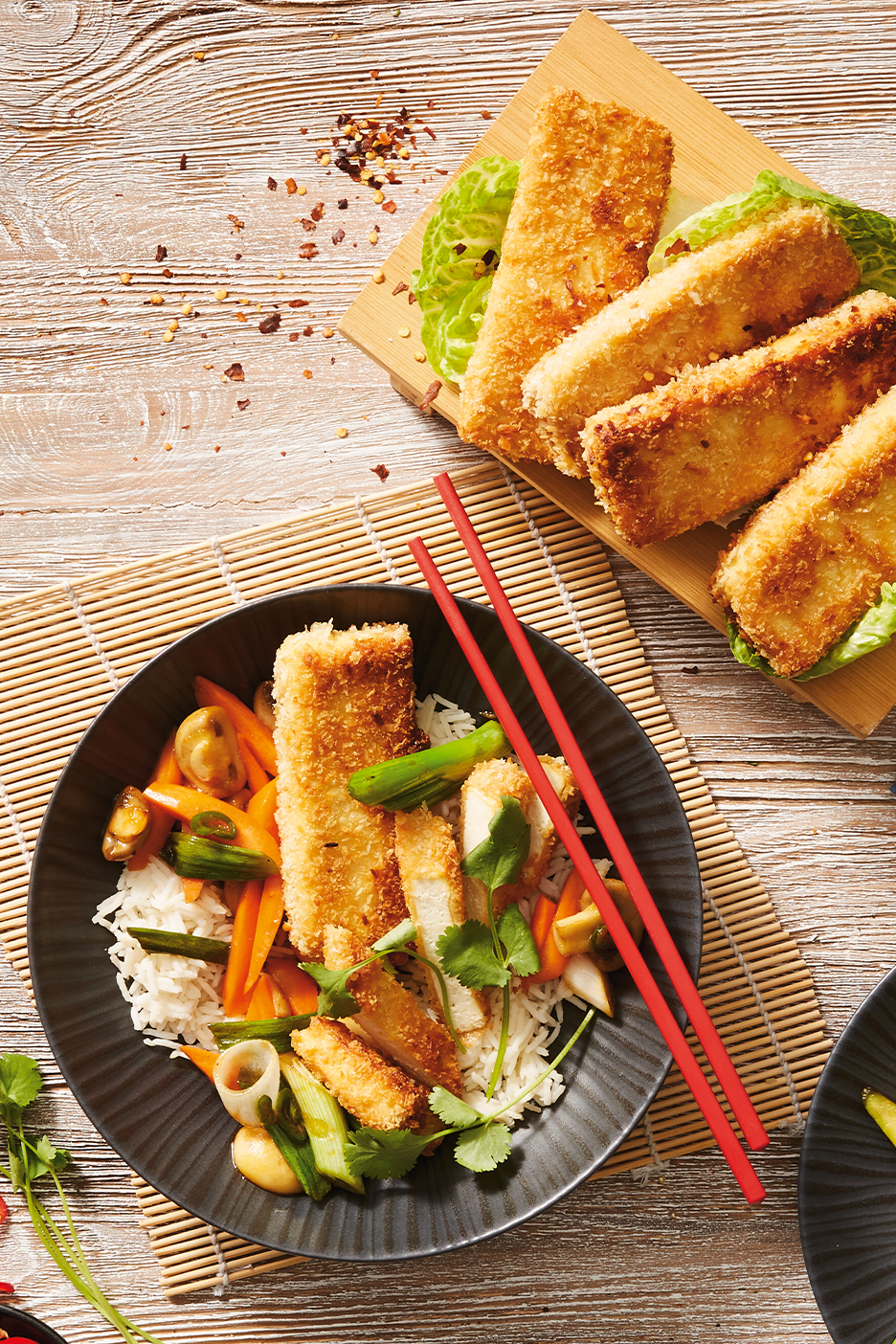 Ropogós tofu és zöldséges rizs tál, pálcikákkal és chilipehellyel.