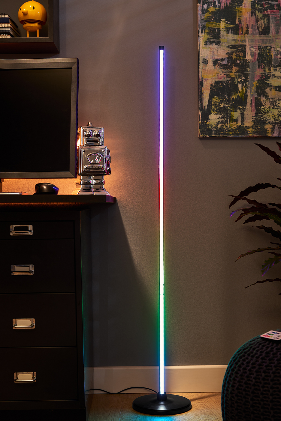 MI/AI segítségével létrehozott/módosított kép: Színes fénnyel világító, modern LED-es állólámpa egy szoba sarkában.
