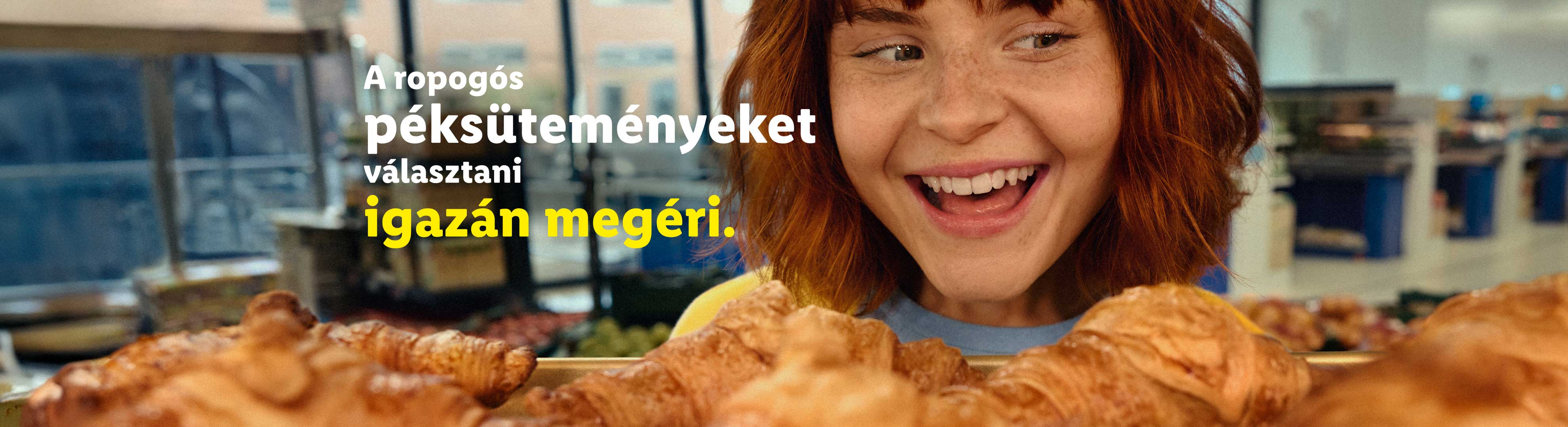 Egy mosolygós nő néz ropogós péksüteményeket egy boltban.