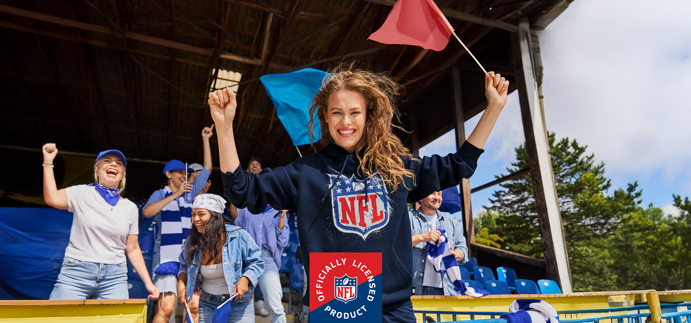 NFL pulóveres nő szurkolókkal egy stadionban, hivatalos NFL termék logóval