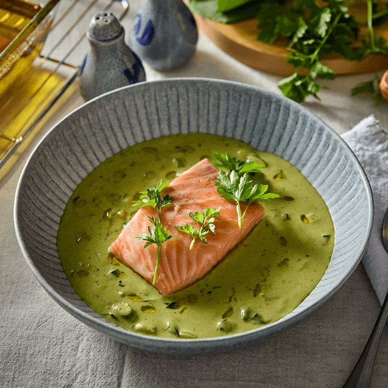 Lazacfilé zöld krémlevesben, petrezselyemmel és tökmaggal díszítve.