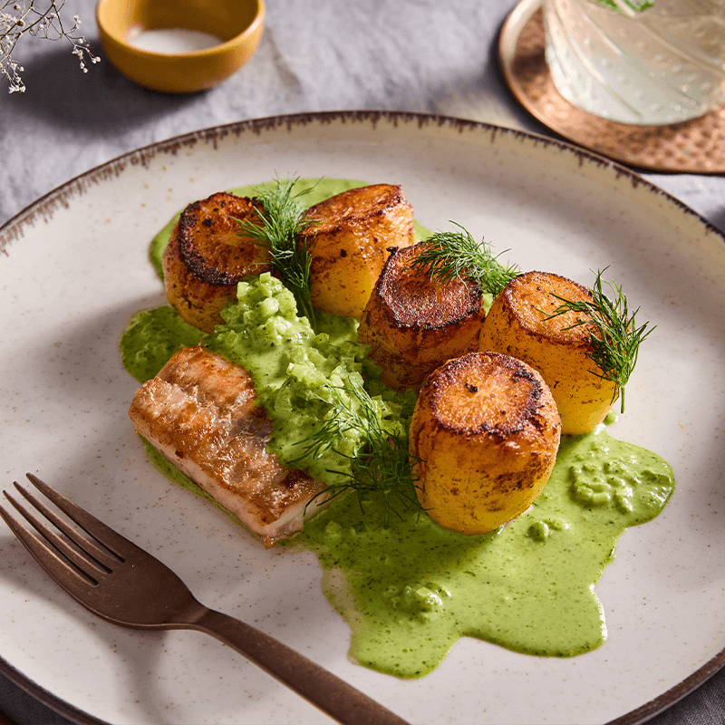 Sült halfilé, sült burgonya és zöldborsópüré krémes szósszal, kaporral díszítve.