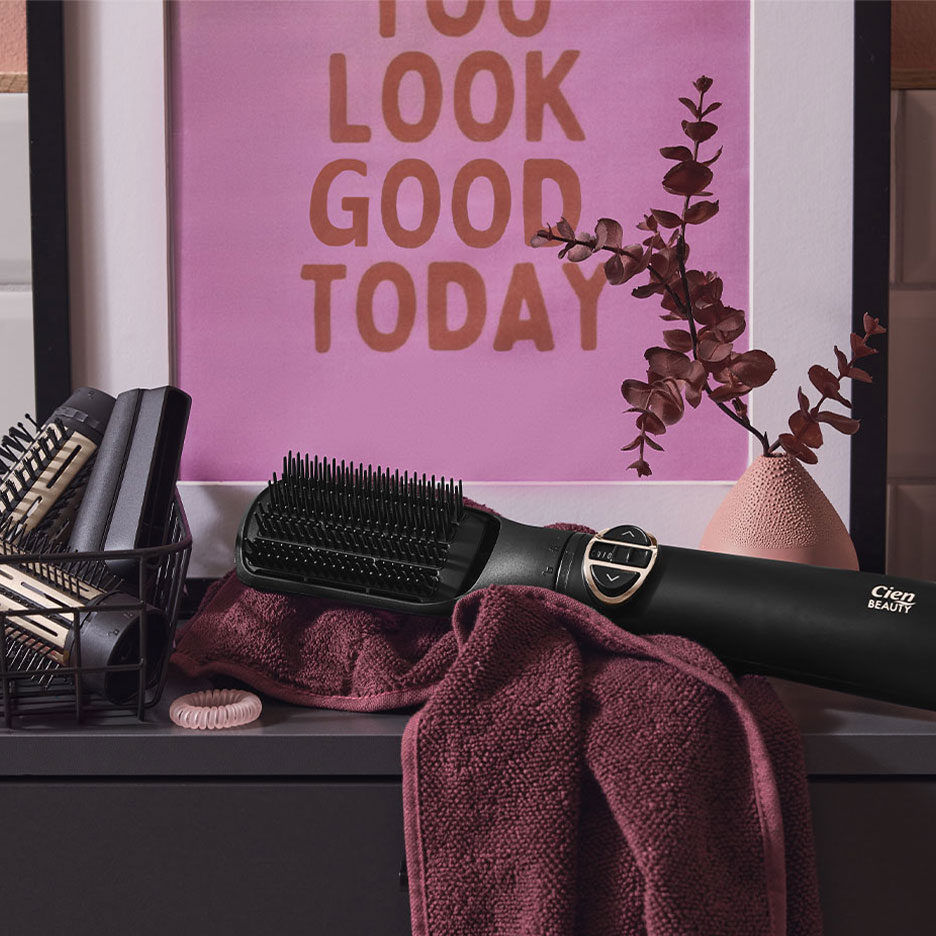 Cien Beauty hajegyenesítő kefe törölközőn, haj kiegészítőkkel és poszterrel.