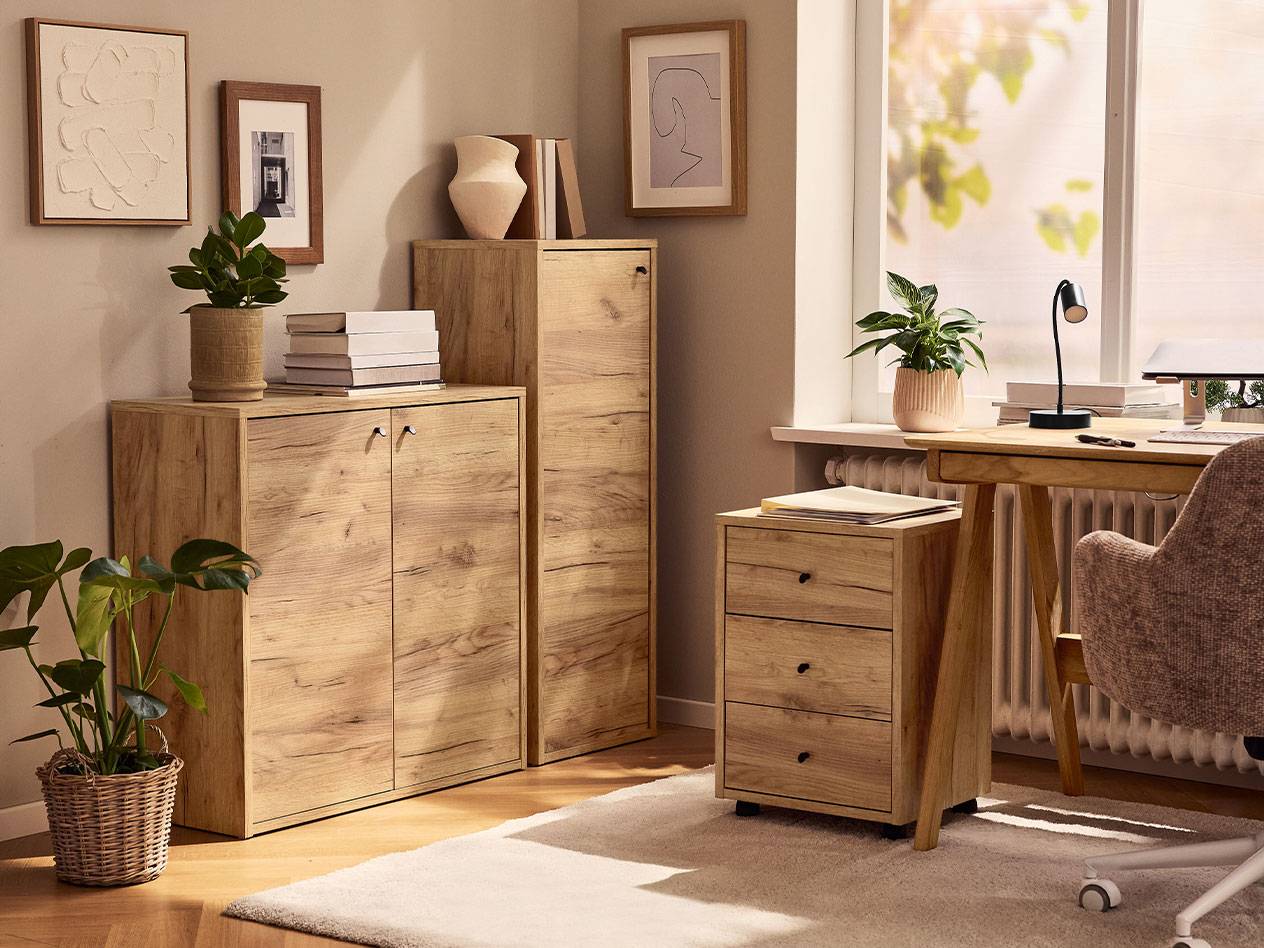 Otthoni iroda világos fa szekrényekkel, íróasztali székkel és asztali lámpával.