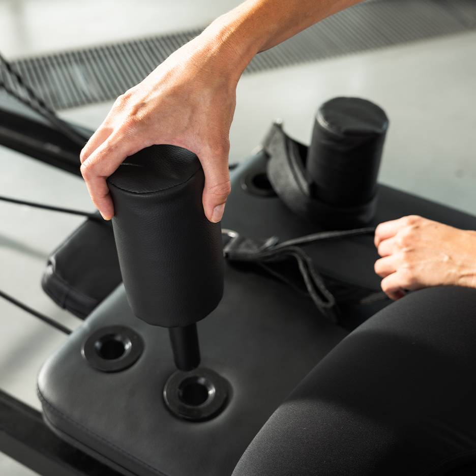 Személy állít egy fekete párnázott edzőgépet.