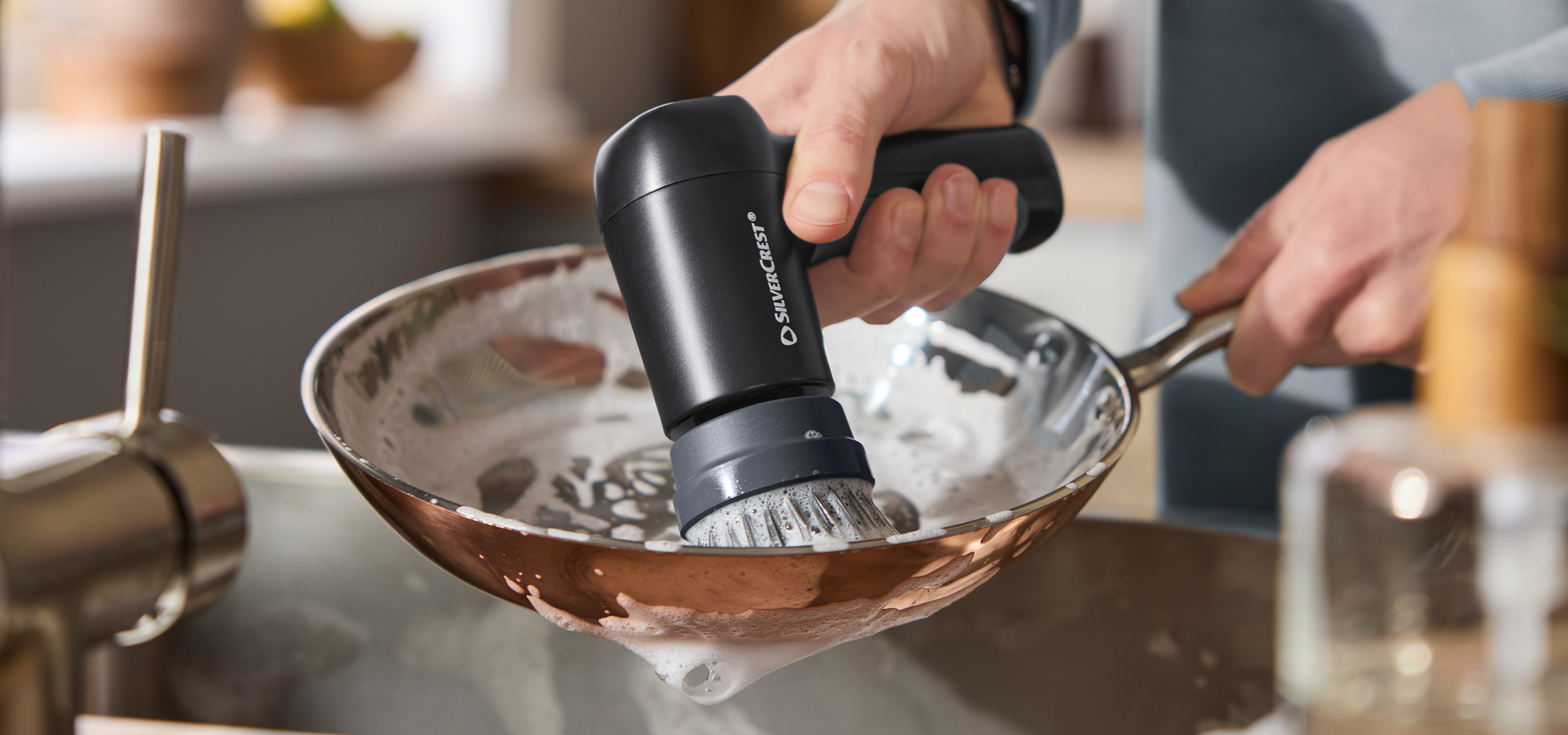 Pár tisztítószer és egy porszívó egy párral, akik otthon takarítanak.