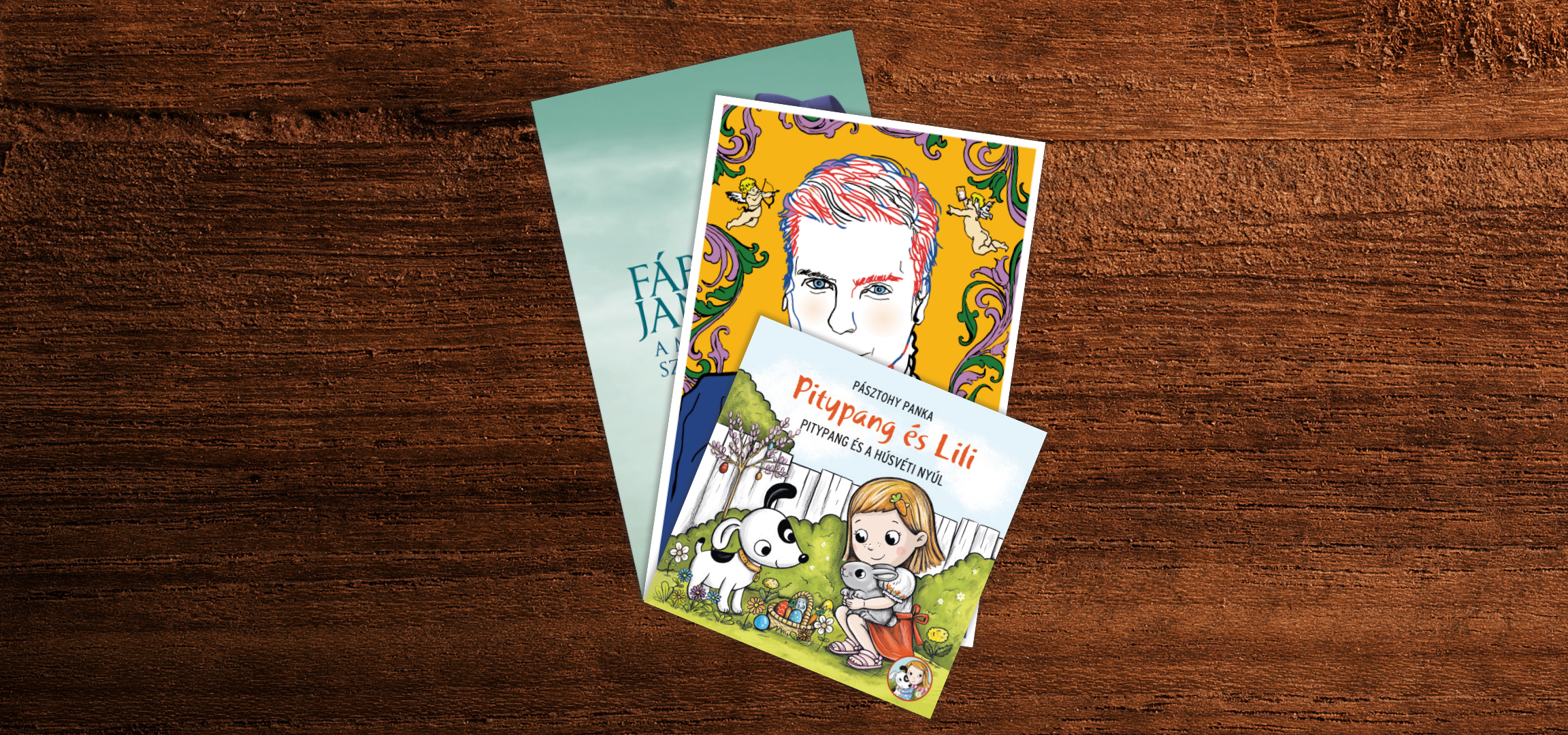 Három könyv, köztük egy fiú portréjával és egy kislány kutyával és nyúllal, barna fa felületen.