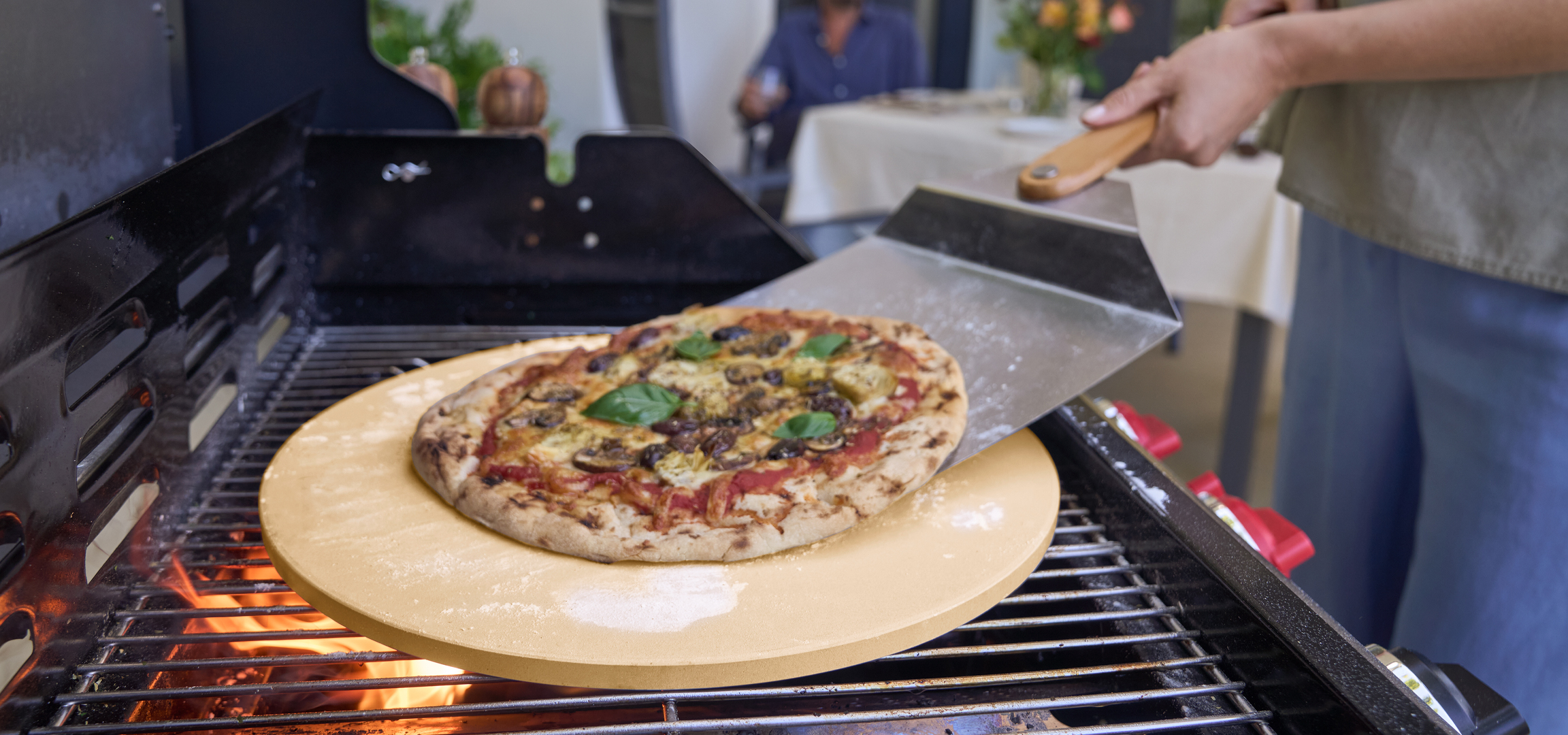 Pizza sütése grillen, pizzakővel és pizzalapáttal.