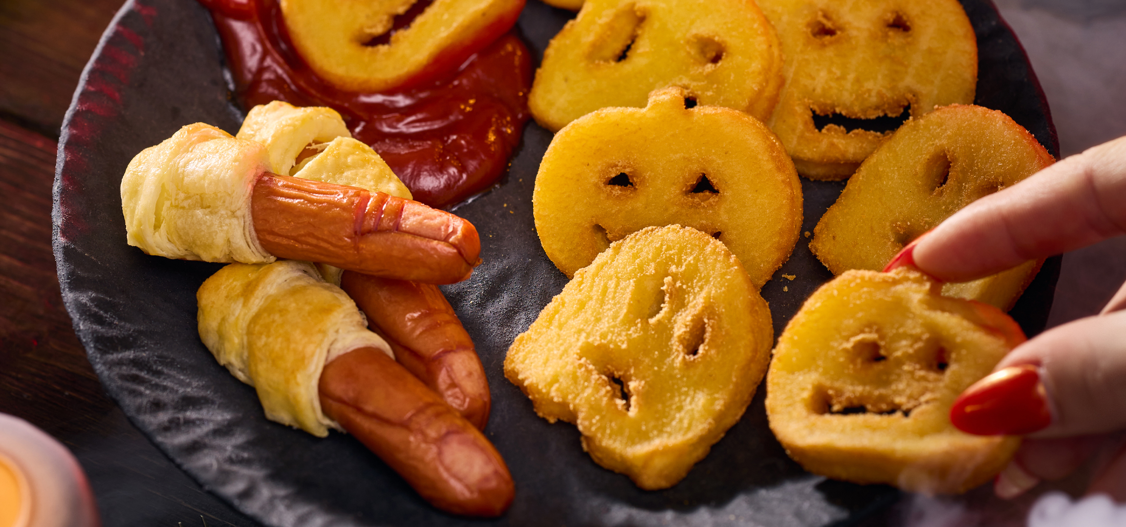 MI/AI segítségével létrehozott/módosított kép: Halloween-i témájú falatkák, múmia virslik és mosolygós burgonyafejek füstös háttérrel.