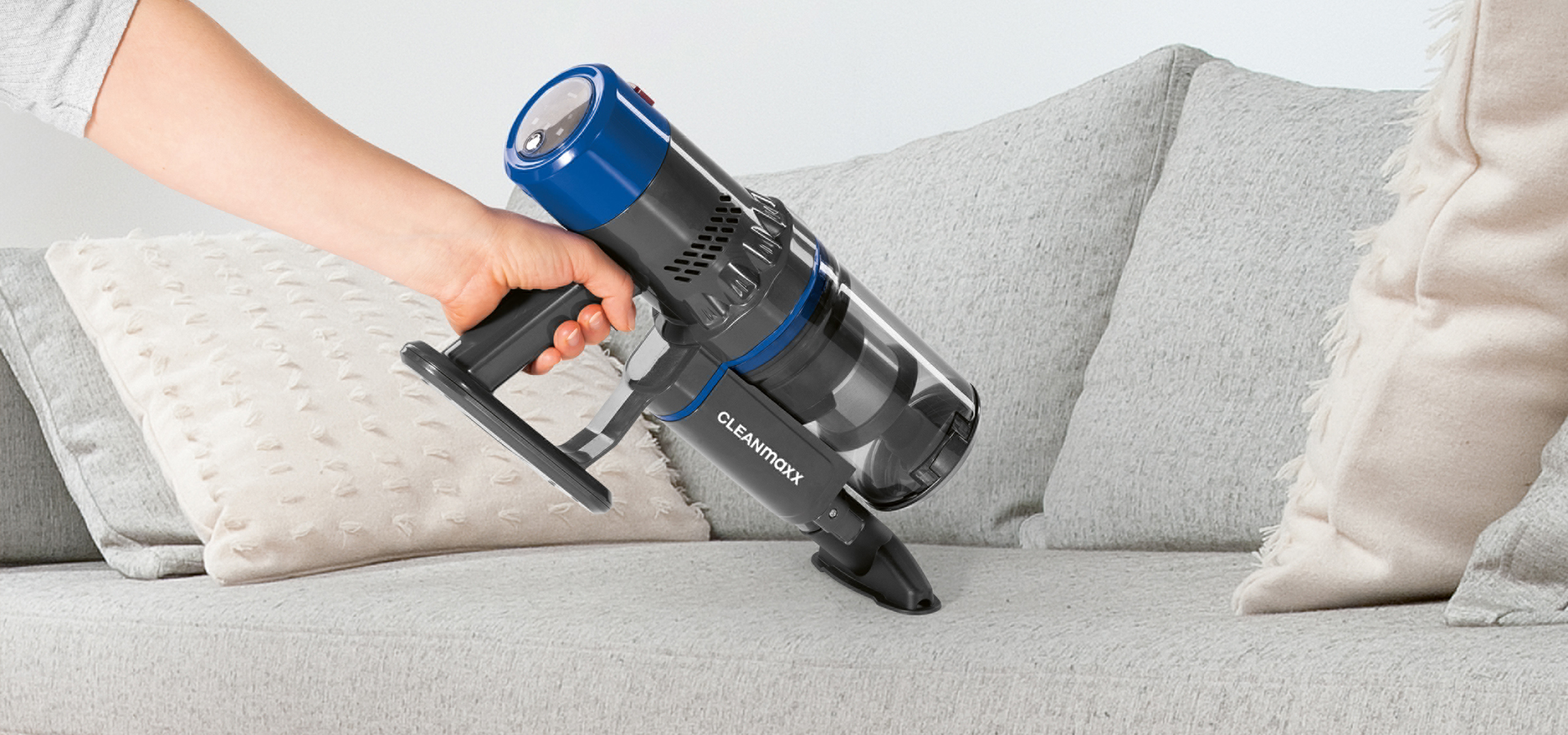 Gőzállomás és vasaló vasalódeszkán, ruhákkal egy világos szobában.