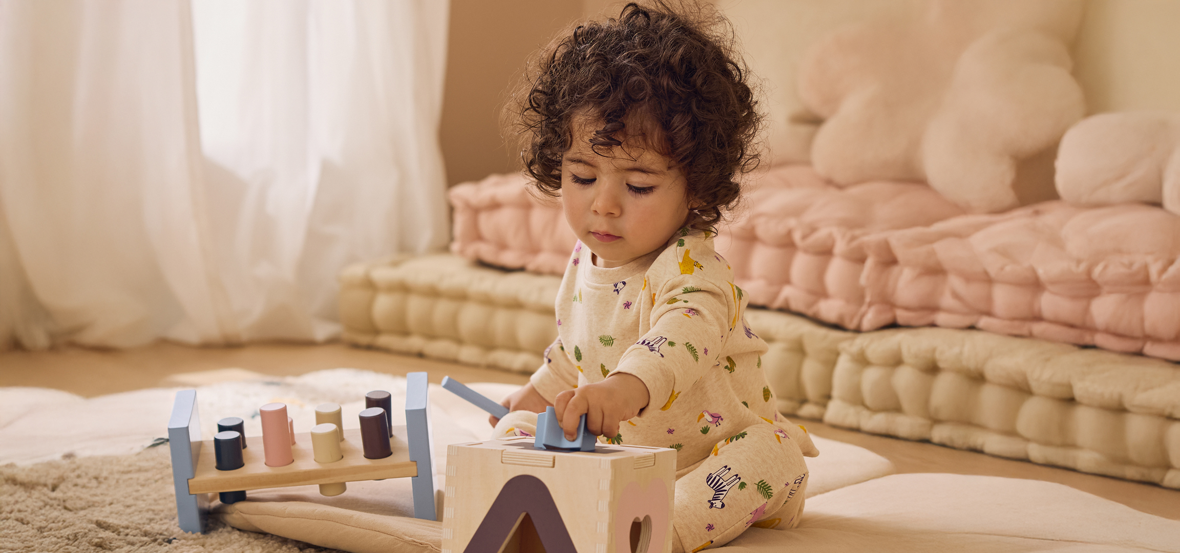 Mosolygó nő kék-fekete mintás ruhában, kezét a hasán tartva