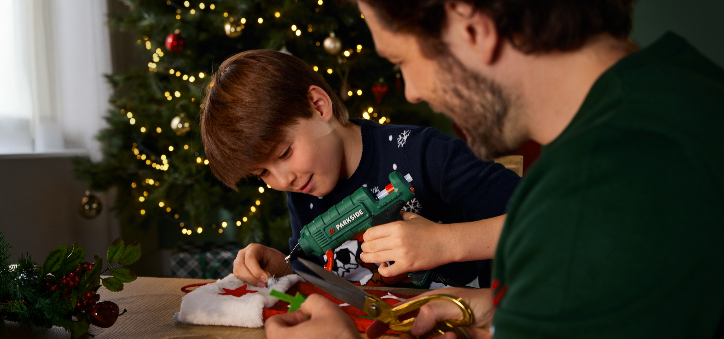 Apa és fia karácsonyi dekorációt készítenek Parkside ragasztópisztollyal.