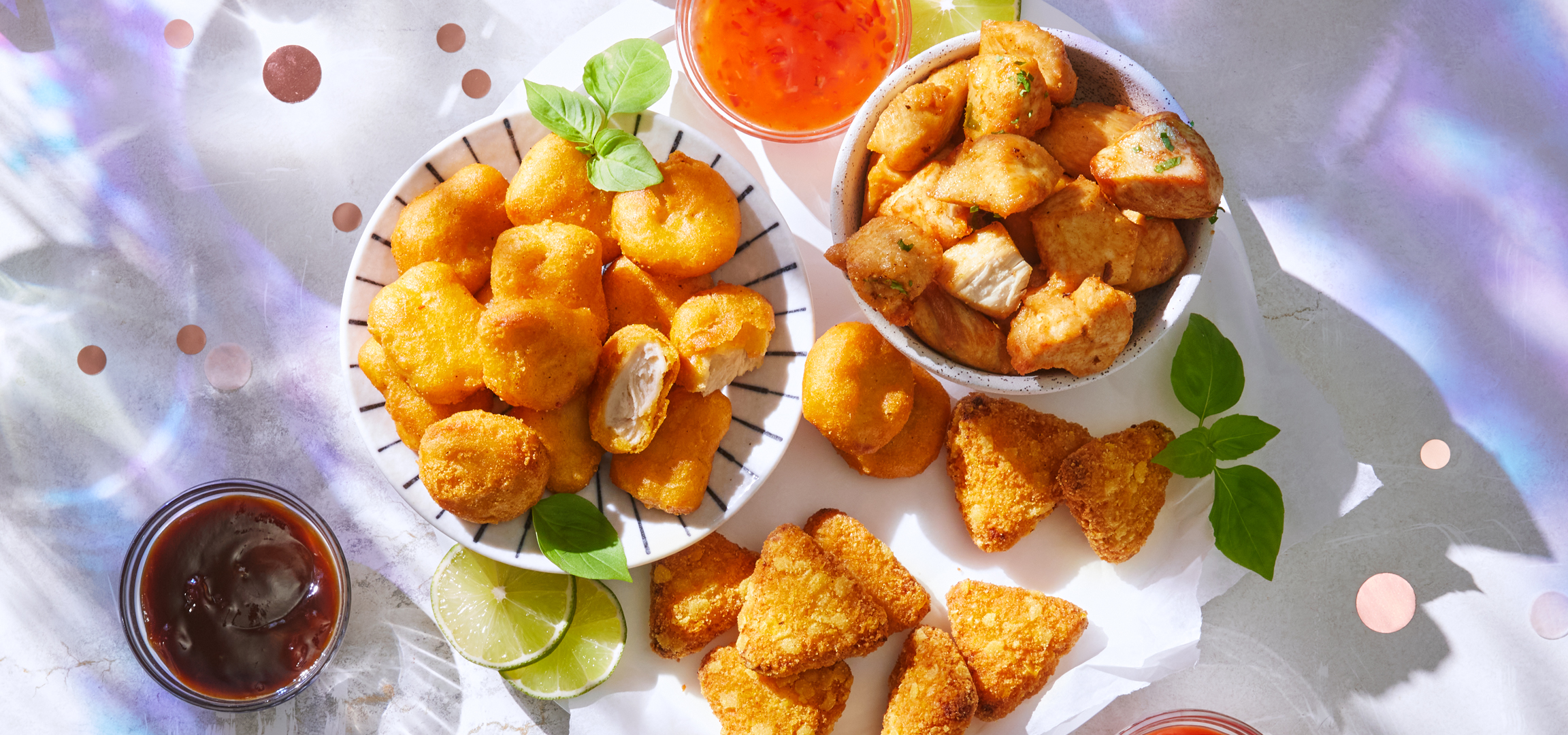 Ropogós csirke falatkák, nuggets és szószok ünnepi asztalon, konfettivel és szalagokkal.