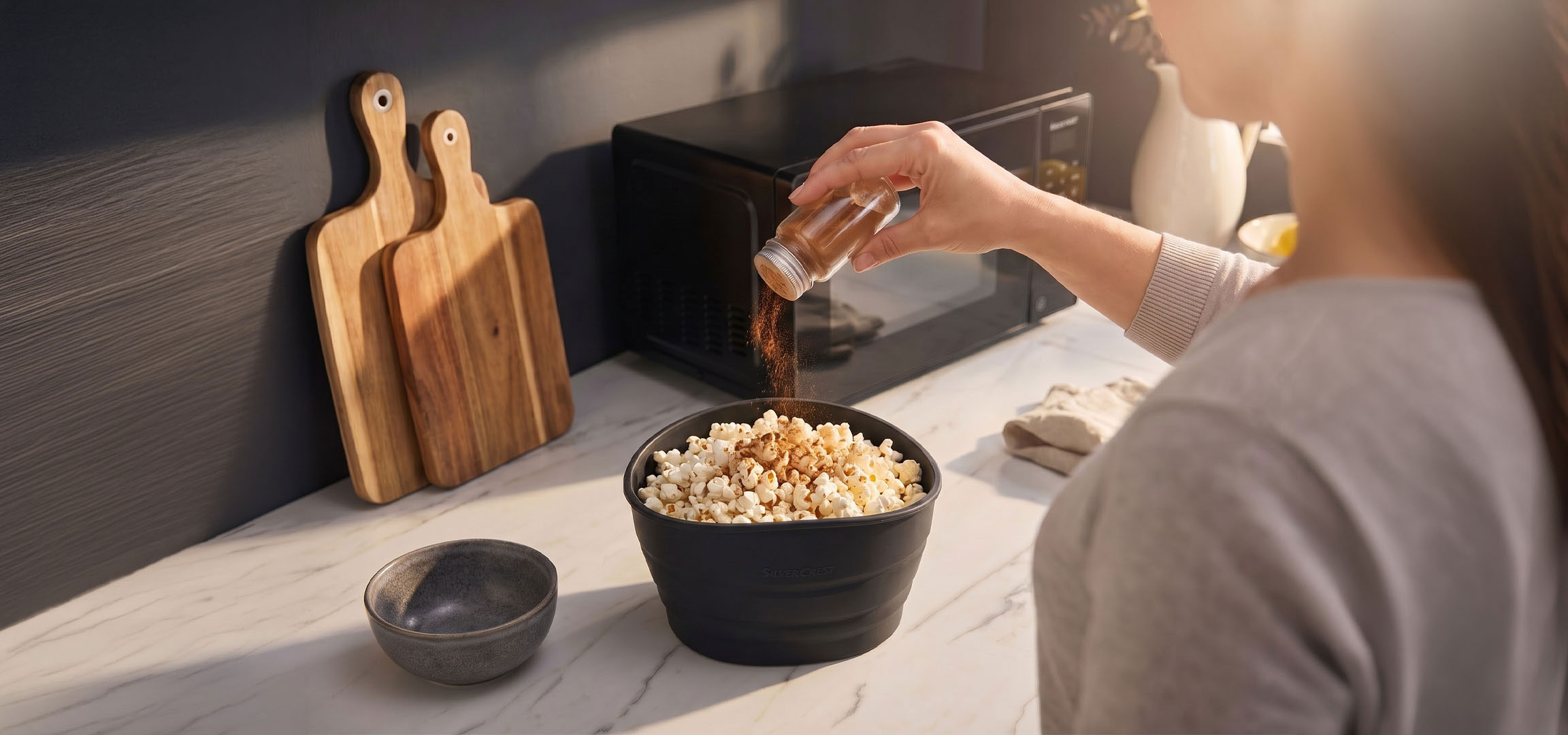 MI/AI segítségével létrehozott/módosított kép: Popcorn fekete tálban fűszerekkel ízesítve, fa vágódeszkák mellett.