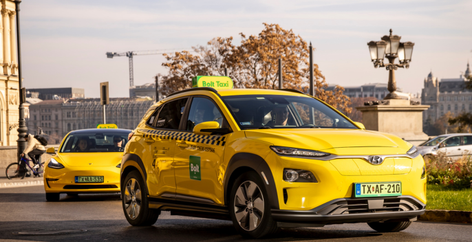 Sárga taxik az utcán, a háttérben épületek és fák láthatók.