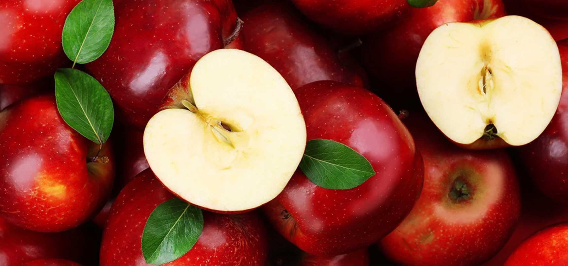 Vörös almák és félbevágott almák levelekkel.