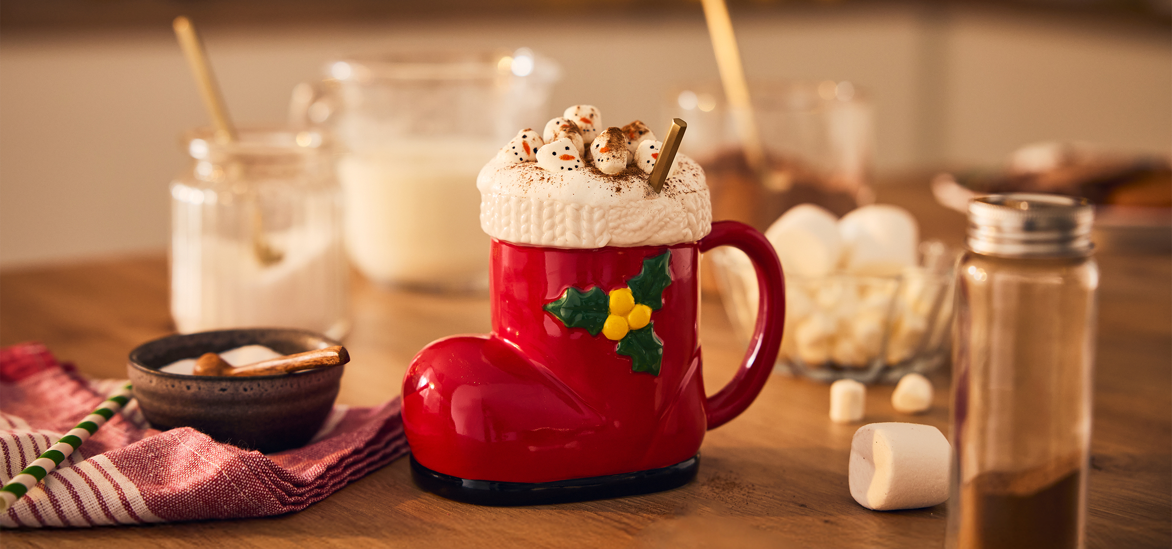 Forró csokoládé karácsonyi csizmás bögrében, habbal és hóemberes mályvacukorral.