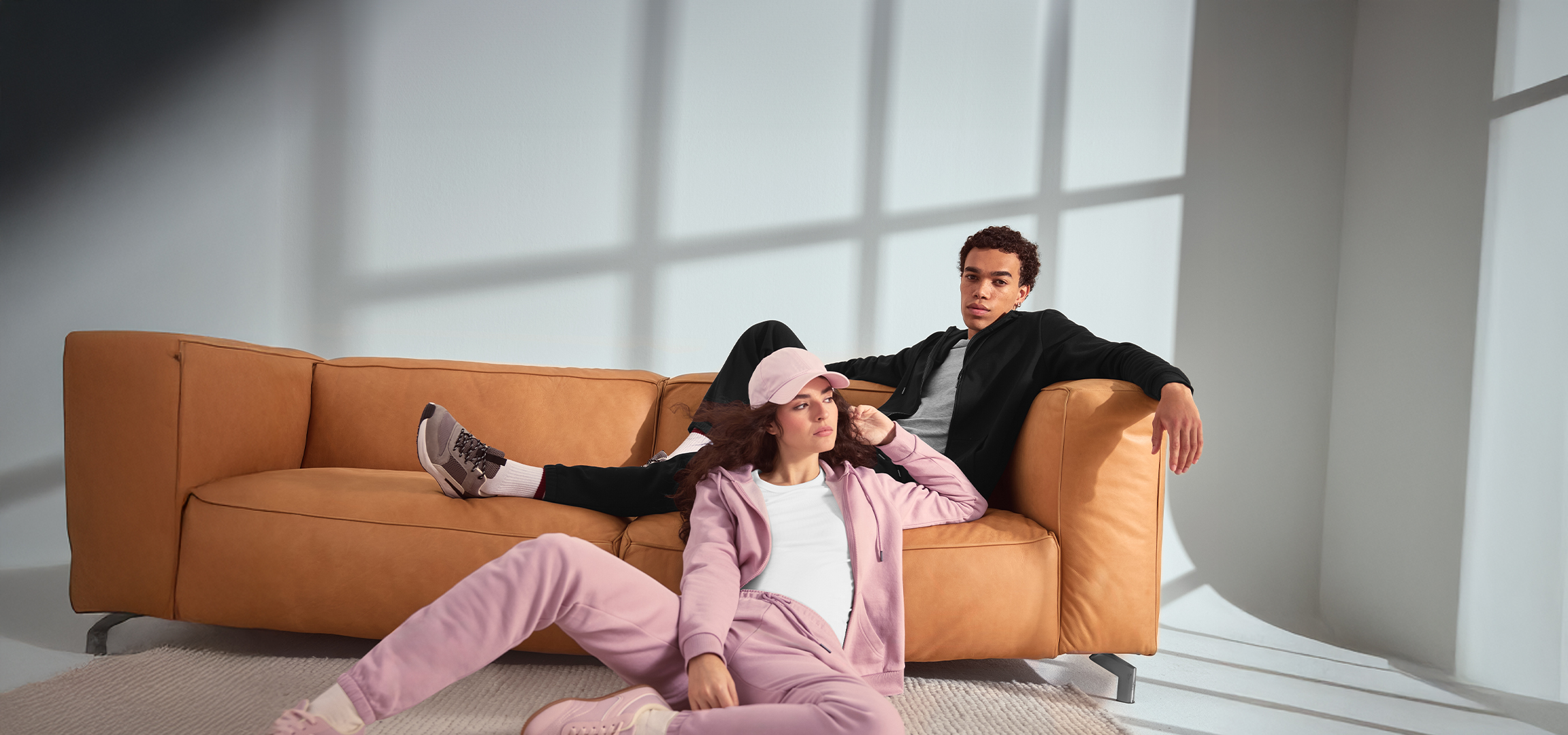 Fiatal pár pihen a kanapén, sportruházatot visel.