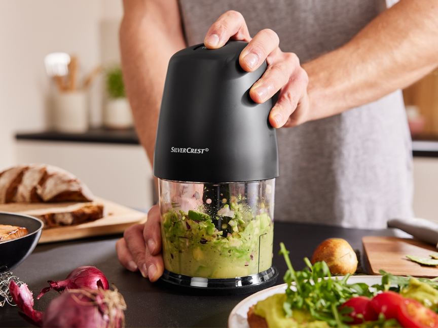 Egy férfi egy SilverCrest aprítógéppel készít guacamole-t.