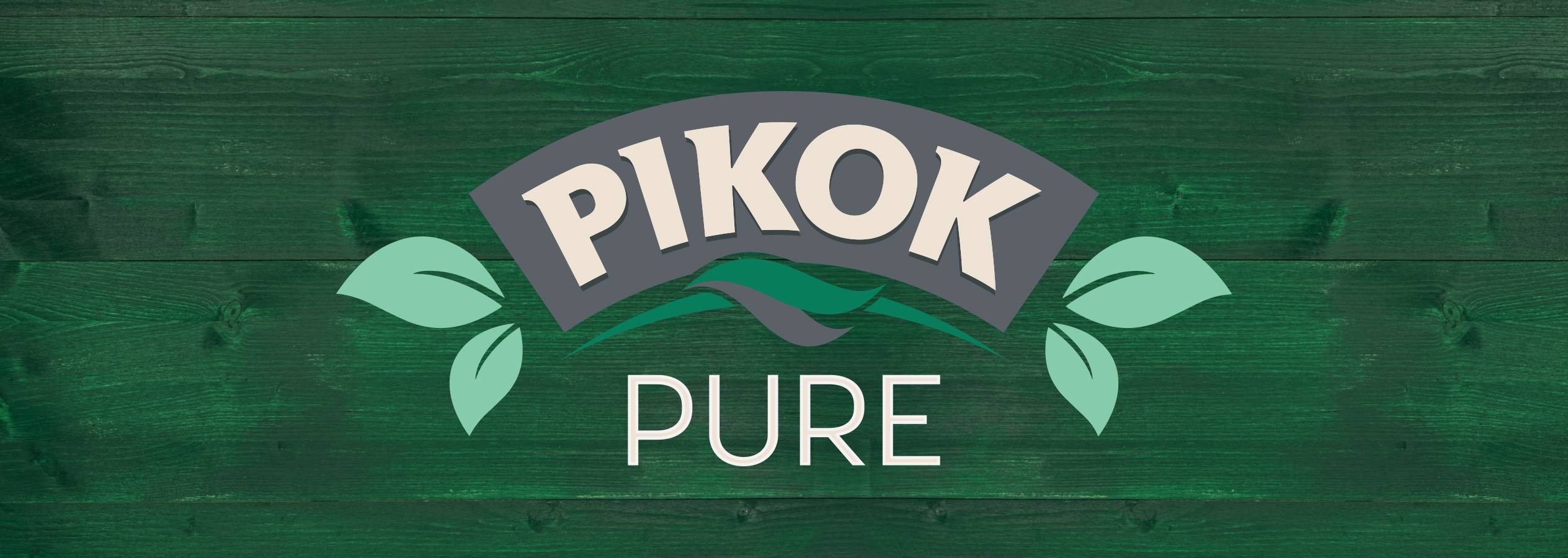 Pikok Pure logó zöld fa háttéren, levelekkel és hullámokkal.