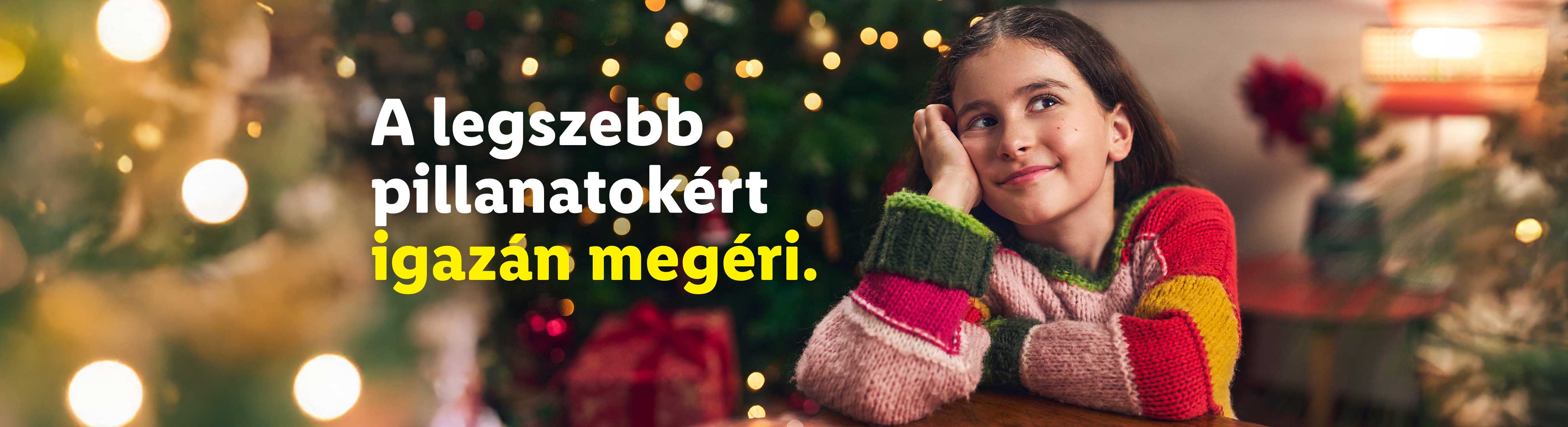 A legszebb pillanatokért igazán megéri. Lány karácsonyi pulóverben, karácsonyfa előtt.